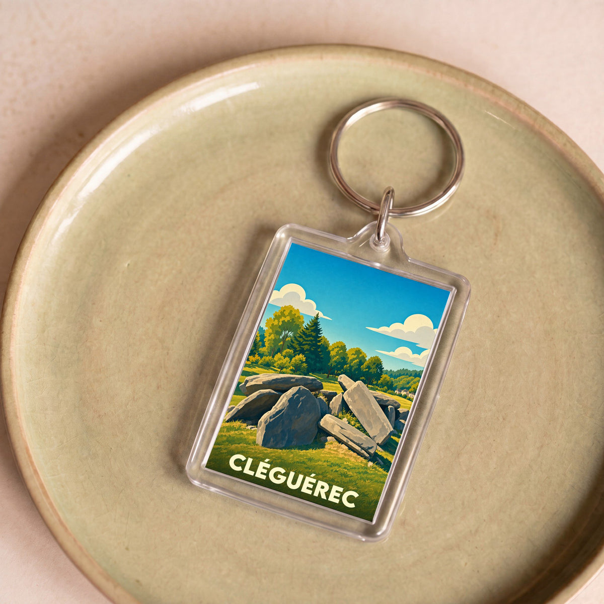 Porte-clés souvenir de la ville de Cléguérec avec une illustration stylisée de mégalithes.