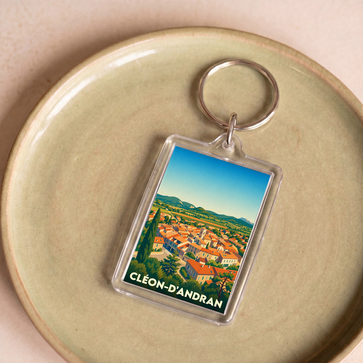 Porte-clés souvenir de la ville de Cléon-d'Andran avec une illustration stylisée.