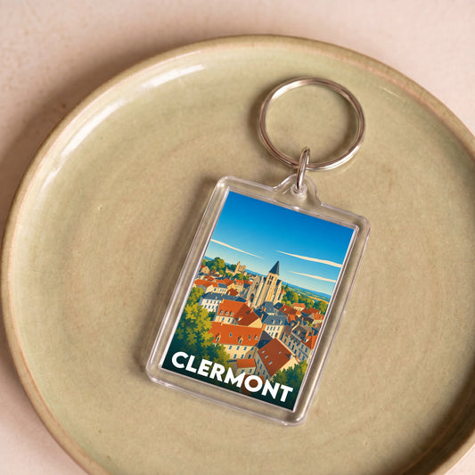 Porte-clés souvenir de la ville de Clermont avec une illustration stylisée d'un paysage urbain.