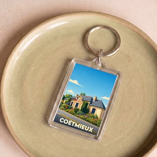 Porte-clés souvenir de la ville de Coëtmieux avec une illustration stylisée de sa mairie.