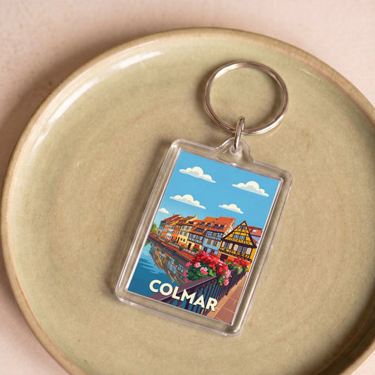 Porte-clés souvenir de la ville de Colmar avec une illustration stylisée de maisons à colombages.