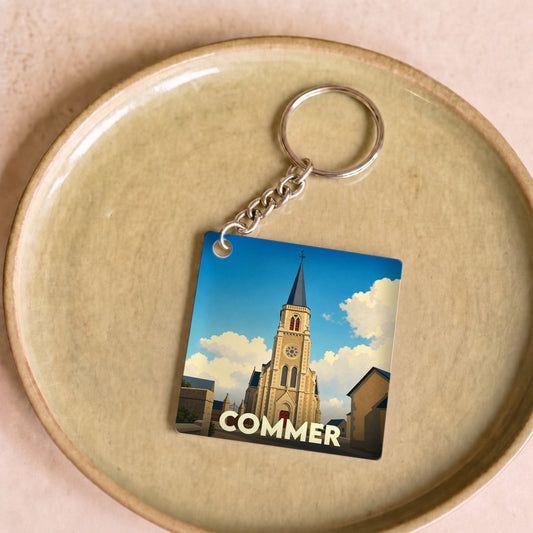 Porte-clés souvenir de la ville de Commer avec une illustration stylisée de son église.