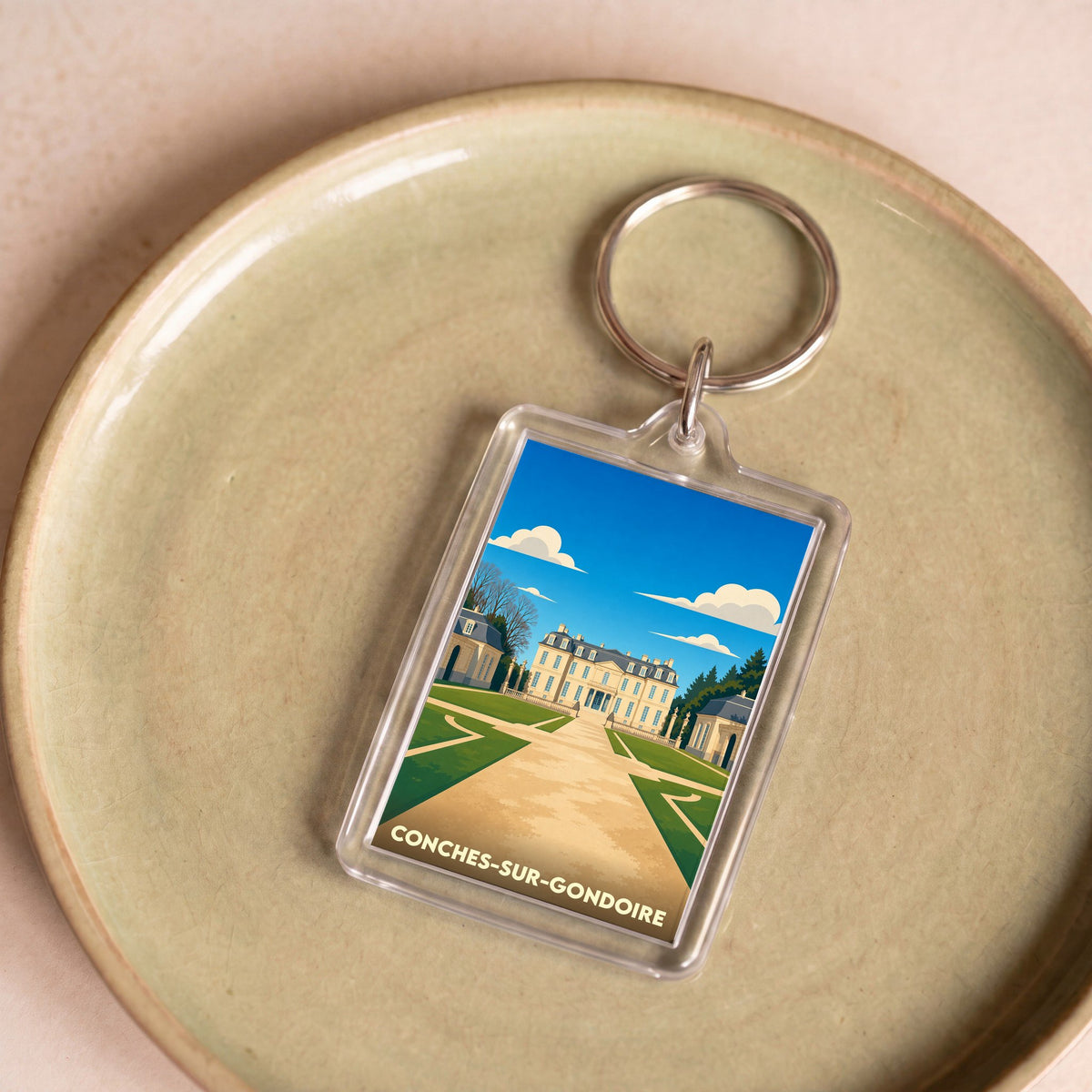 Porte-clés souvenir de la ville de Conches-sur-Gondoire avec une illustration stylisée de son château.