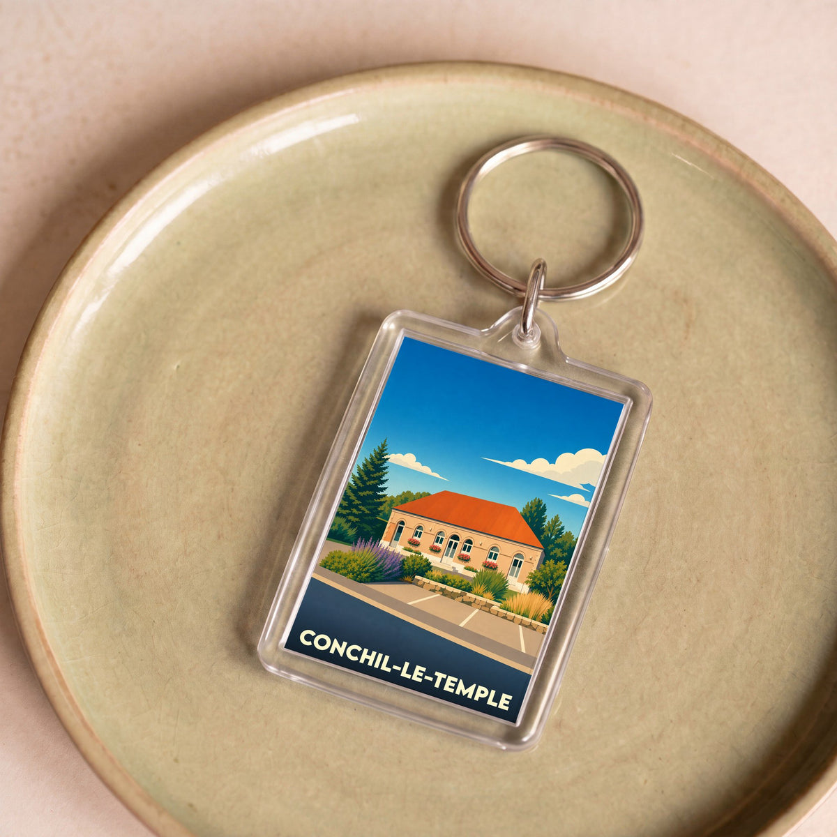 Porte-clés souvenir de la ville de Conchil-le-Temple avec une illustration stylisée.