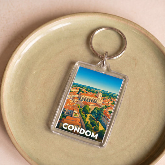 Porte-clés souvenir de la ville de Condom avec une illustration stylisée de sa cathédrale et de ses toits.
