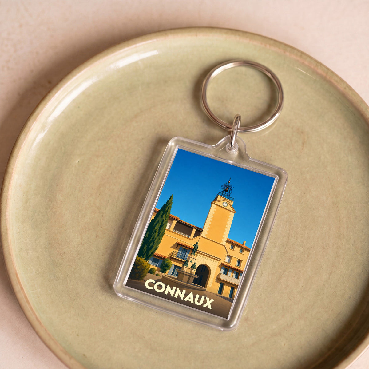 Porte-clés souvenir de la ville de Connaux avec une illustration stylisée de sa tour de l'horloge.
