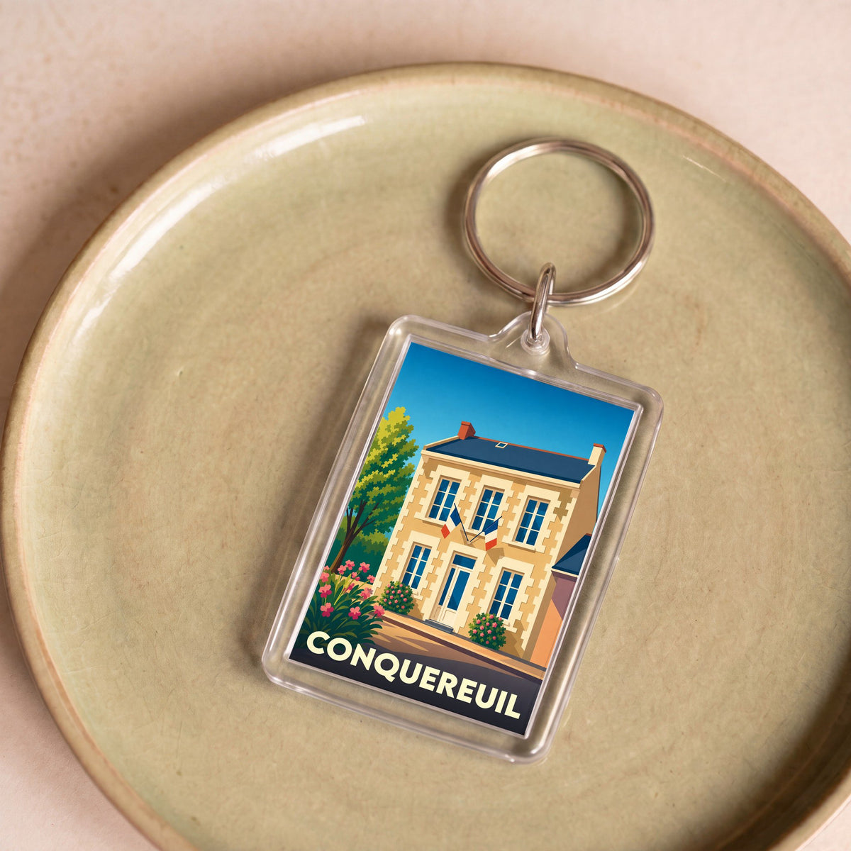 Porte-clés souvenir de la ville de Conquereuil avec une illustration stylisée.