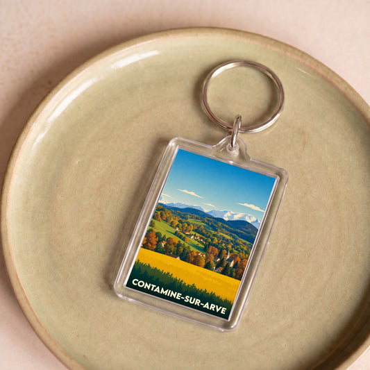 Porte-clés souvenir de la ville de Contamine-sur-Arve avec une illustration stylisée de paysages montagneux.