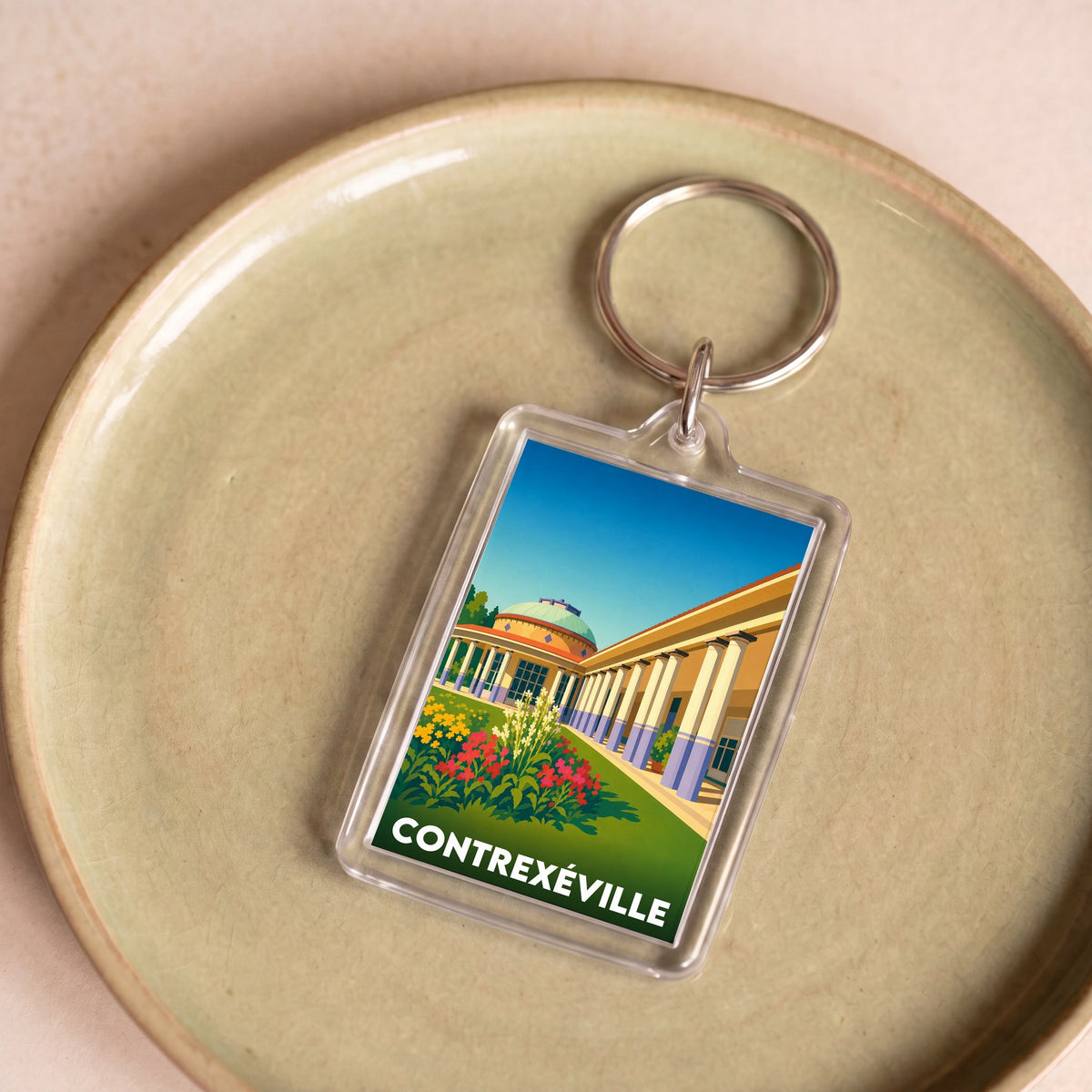 Porte-clés souvenir de la ville de Contrexéville avec une illustration stylisée.