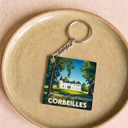 Porte-clés souvenir de la ville de Corbeilles avec une illustration stylisée d'un château entouré d'arbres.