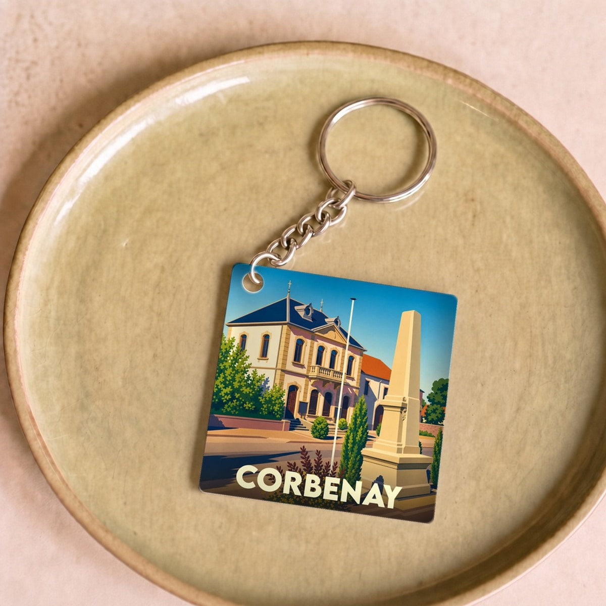 Porte-clés souvenir de la ville de Corbenay avec une illustration stylisée de son patrimoine.