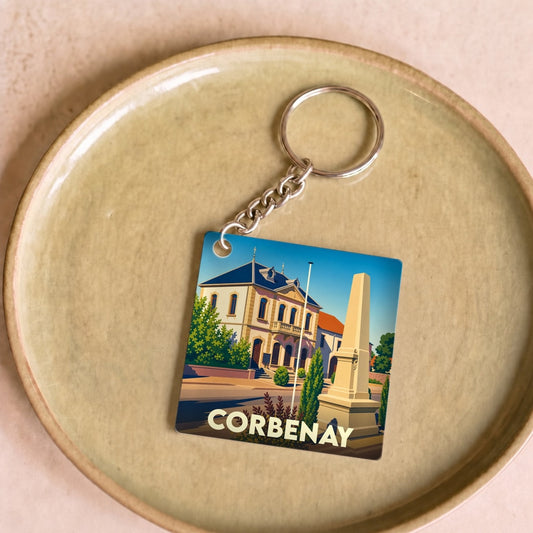 Porte-clés souvenir de la ville de Corbenay avec une illustration stylisée de son patrimoine.