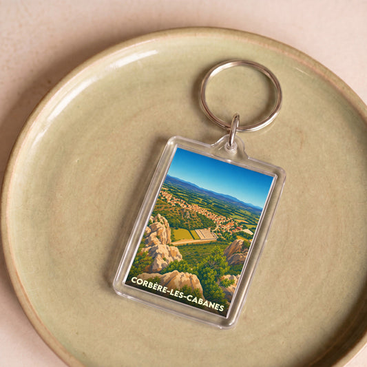 Porte-clés souvenir de la ville de Corbère-les-Cabanes avec une illustration stylisée de son paysage.