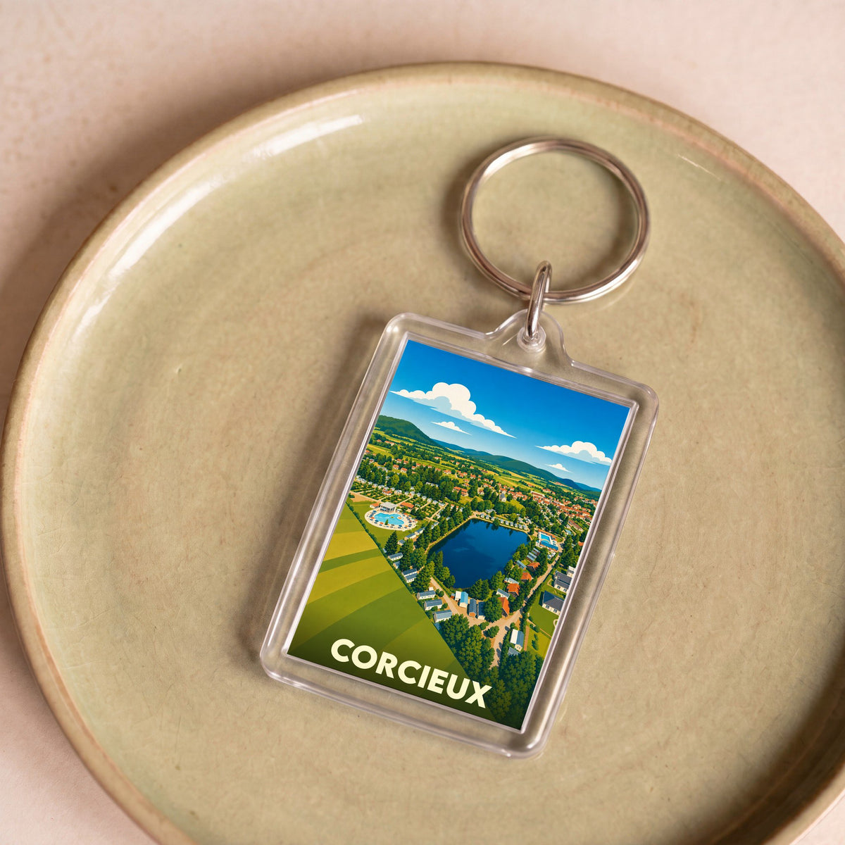 Porte-clés souvenir de la ville de Corcieux avec une illustration stylisée.