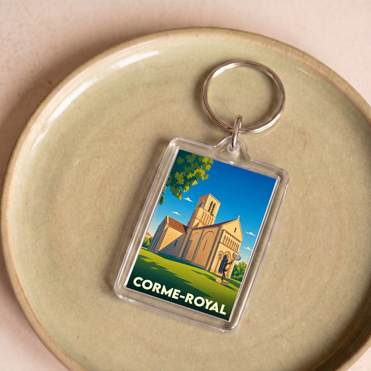 Porte-clés souvenir de la ville de Corme-Royal avec une illustration stylisée de son église.