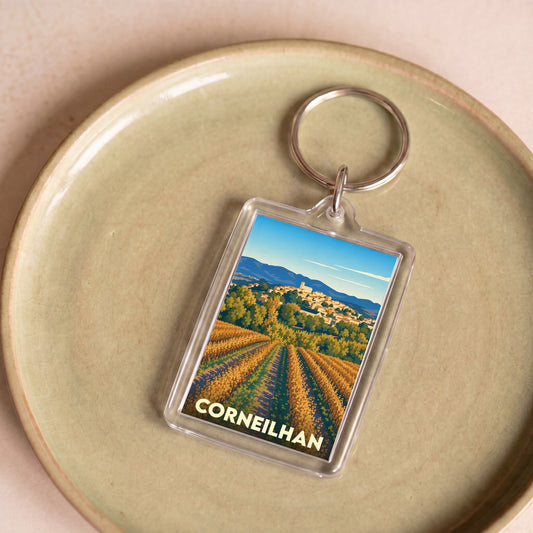 Porte-clés souvenir de la ville de Corneilhan avec une illustration stylisée de vignobles et du village.