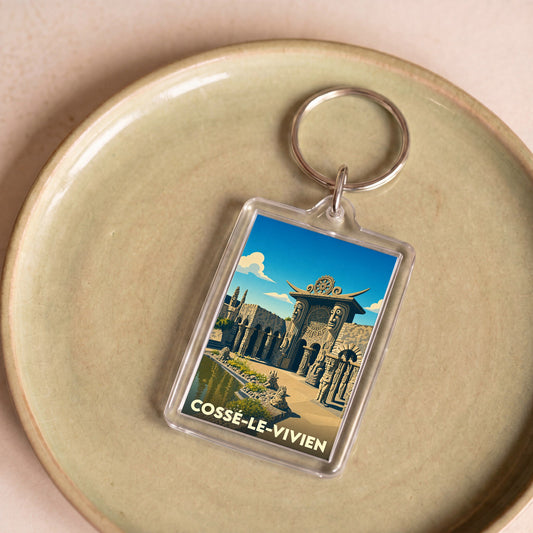 Porte-clés souvenir de la ville de Cossé-le-Vivien avec une illustration stylisée du Musée Robert Tatin.