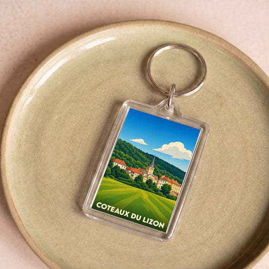 Porte-clés souvenir de la ville de Coteaux du Lizon avec une illustration stylisée de son paysage urbain et naturel.