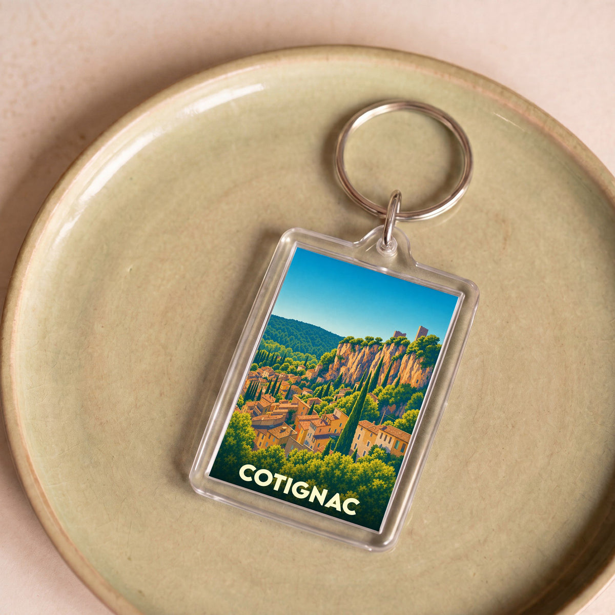Porte-clés souvenir de la ville de Cotignac avec une illustration stylisée.