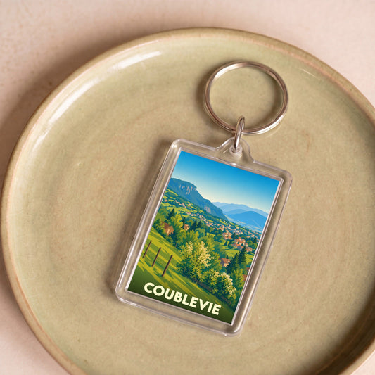 Porte-clés souvenir de la ville de Coublevie avec une illustration paysagère stylisée.