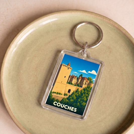 Porte-clés souvenir de la ville de Couches avec une illustration stylisée de son château médiéval.