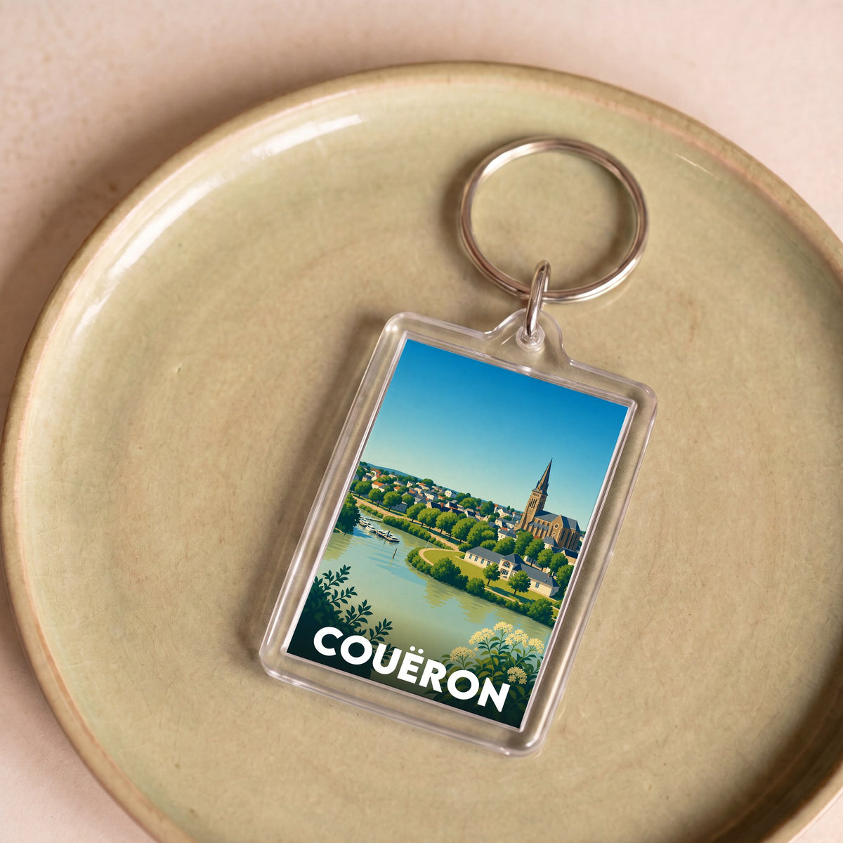 Porte-clés souvenir de la ville de Couëron avec une illustration stylisée du paysage.