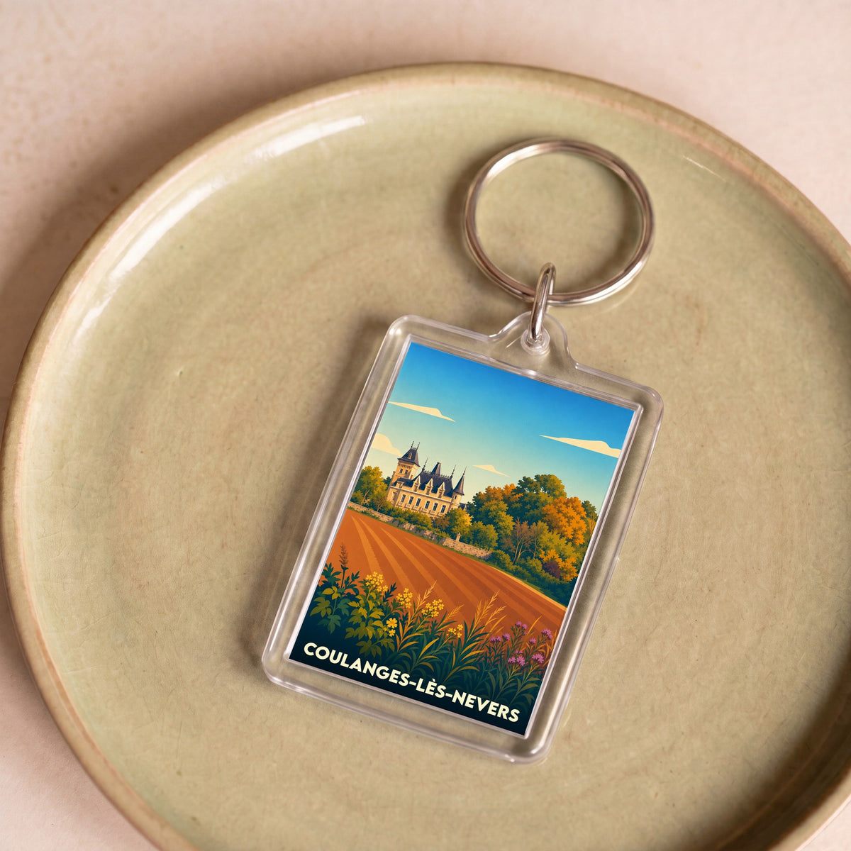 Porte-clés souvenir de la ville de Coulanges-lès-Nevers avec une illustration stylisée.