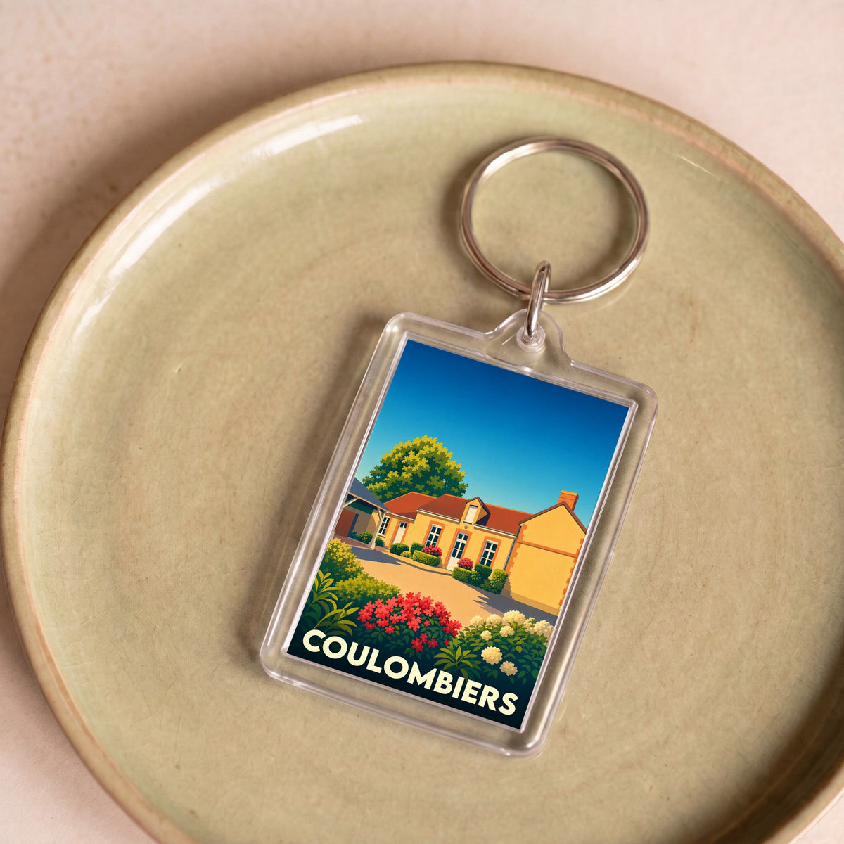 Porte-clés souvenir de la ville de Coulombiers avec une illustration stylisée et colorée.