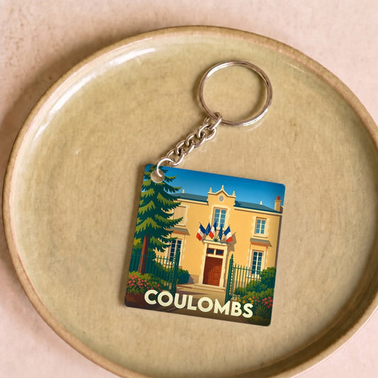 Porte-clés souvenir de la ville de Coulombs avec une illustration stylisée de la mairie.