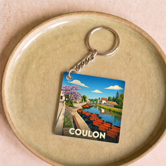 Porte-clés souvenir de la ville de Coulon avec une illustration stylisée de barques sur un canal.