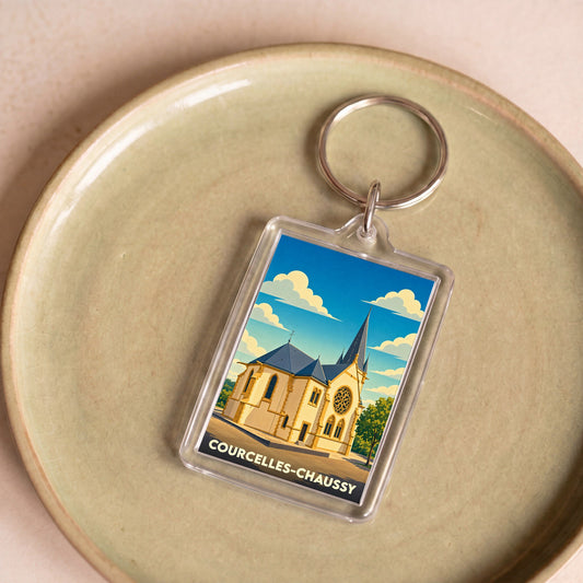 Porte-clés souvenir de la ville de Courcelles-Chaussy avec une illustration stylisée de son église.