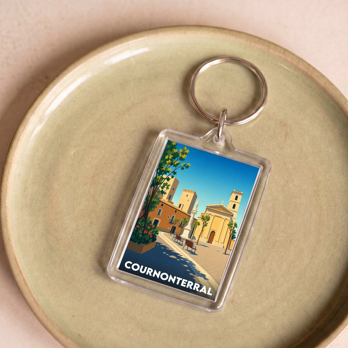 Porte-clés souvenir de la ville de Cournonterral avec une illustration stylisée.