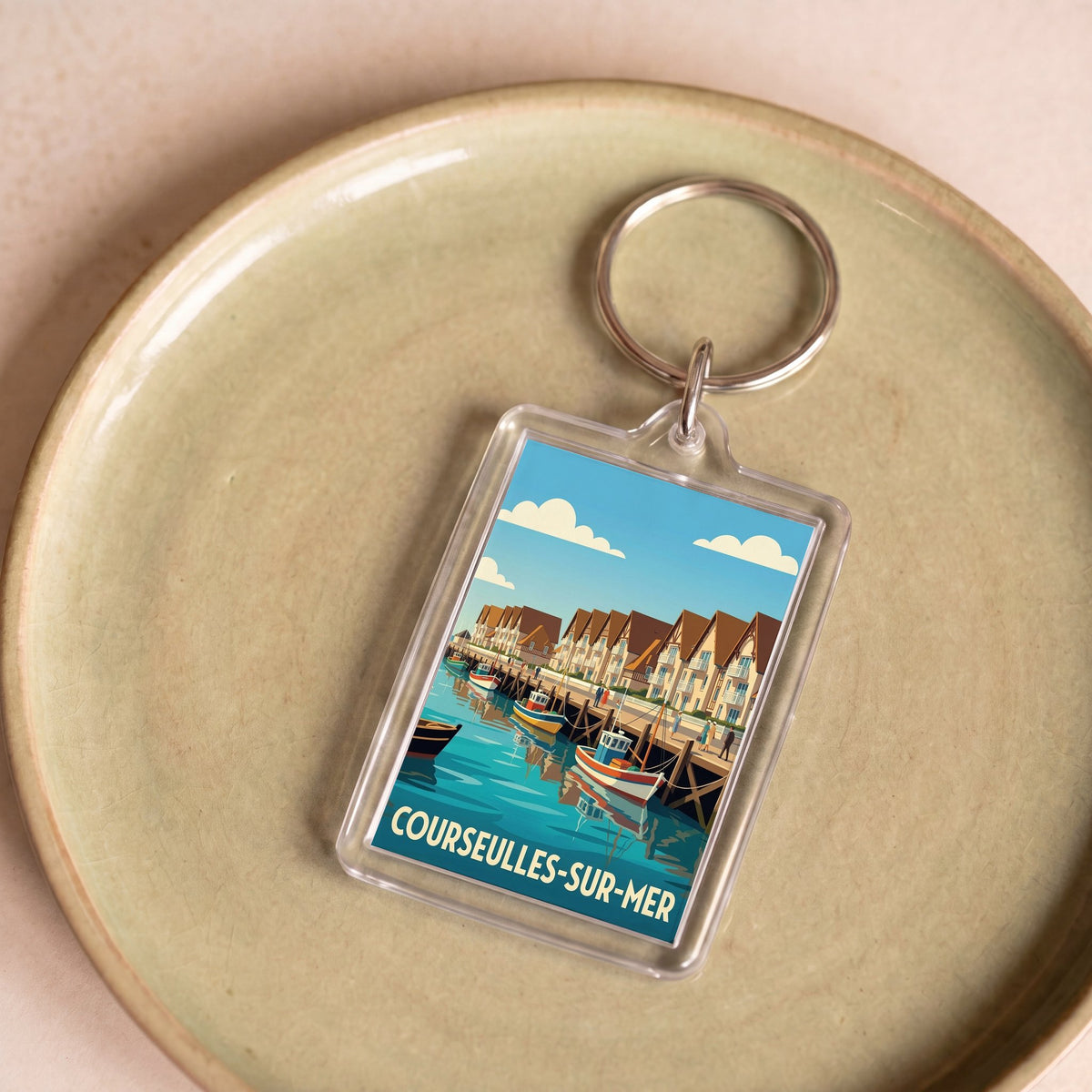 Porte-clés souvenir de la ville de Courseulles-sur-Mer avec une illustration stylisée.