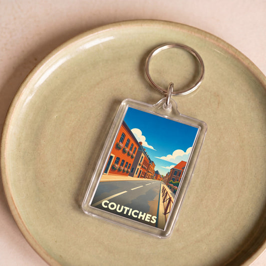 Porte-clés souvenir de la ville de Coutiches avec une illustration stylisée d'une rue colorée.