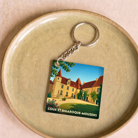 Porte-clés souvenir de la ville de Coux et Bigaroque-Mouzens avec une illustration stylisée.
