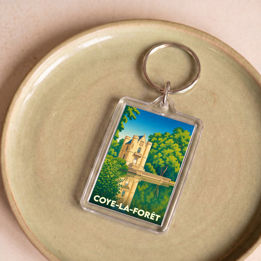 Porte-clés souvenir de la ville de Coye-la-Forêt avec une illustration stylisée de son château.