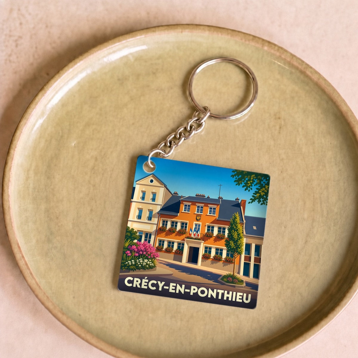 Porte-clés souvenir de la ville de Crécy-en-Ponthieu avec une illustration stylisée.