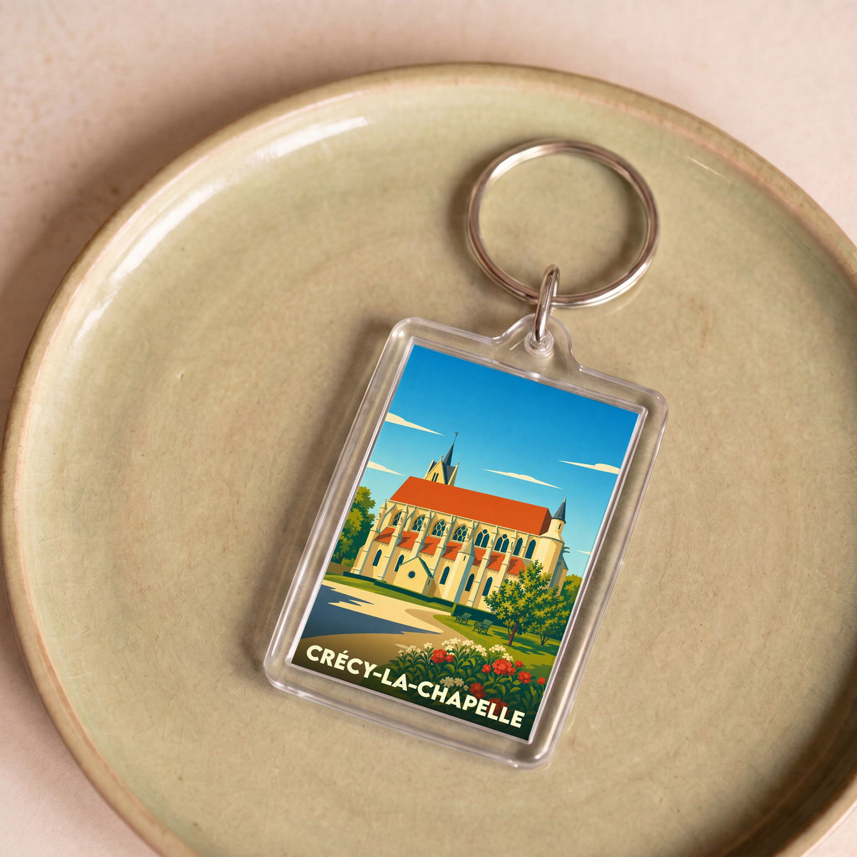 Porte-clés souvenir de la ville de Crécy-la-Chapelle avec une illustration stylisée de son église collégiale.