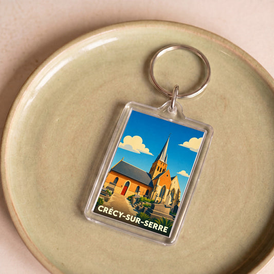 Porte-clés souvenir de la ville de Crécy-sur-Serre avec une illustration stylisée de son église.
