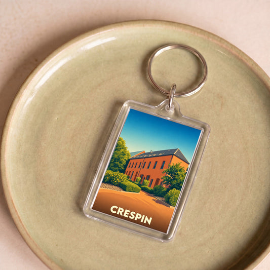Porte-clés souvenir de la ville de Crespin avec une illustration stylisée d'un bâtiment en briques.