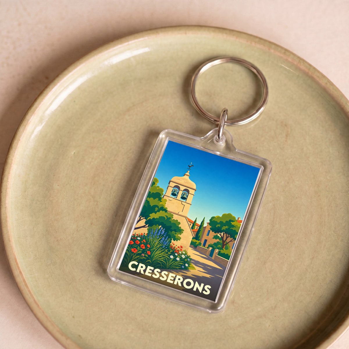 Porte-clés souvenir de la ville de Cresserons avec une illustration stylisée de son clocher.