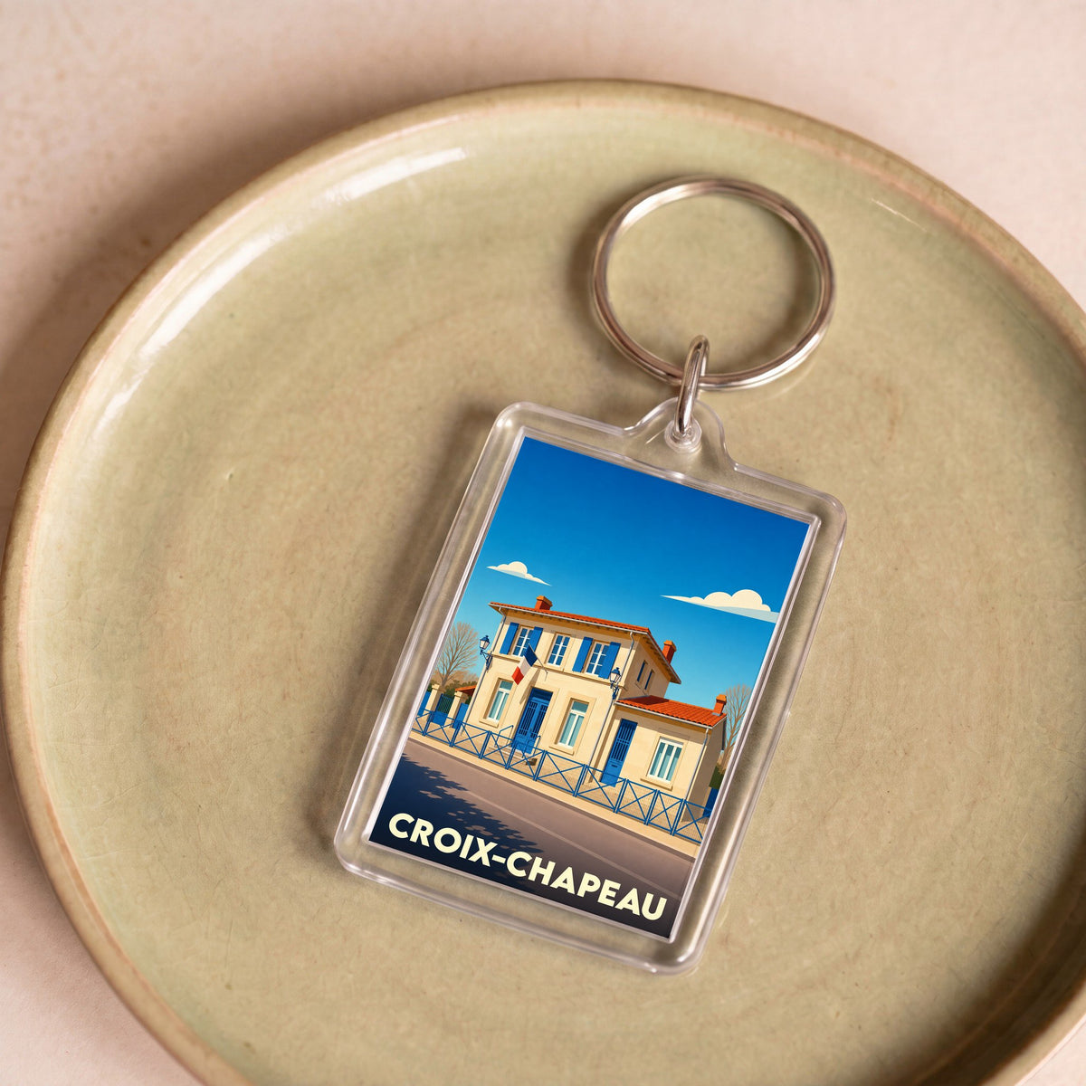 Porte-clés souvenir de la ville de Croix-Chapeau avec une illustration stylisée.