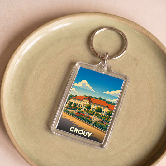 Porte-clés souvenir de la ville de Crouy avec une illustration stylisée.