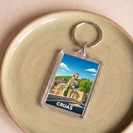 Porte-clés souvenir de la ville de Cruas avec une illustration stylisée de son abbaye médiévale.