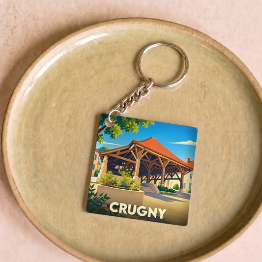 Porte-clés souvenir de la ville de Crugny avec une illustration stylisée d'une halle traditionnelle.