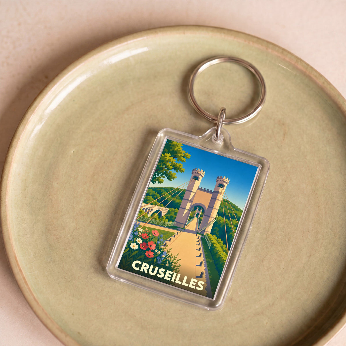 Porte-clés souvenir de la ville de Cruseilles avec une illustration stylisée du pont de la Caille.