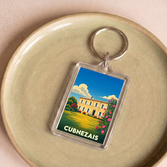 Porte-clés souvenir de la ville de Cubnezais avec une illustration stylisée d'un domaine viticole.
