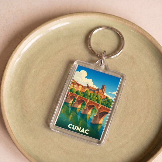 Porte-clés souvenir de la ville de Cunac avec une illustration stylisée de son pont et de son église.