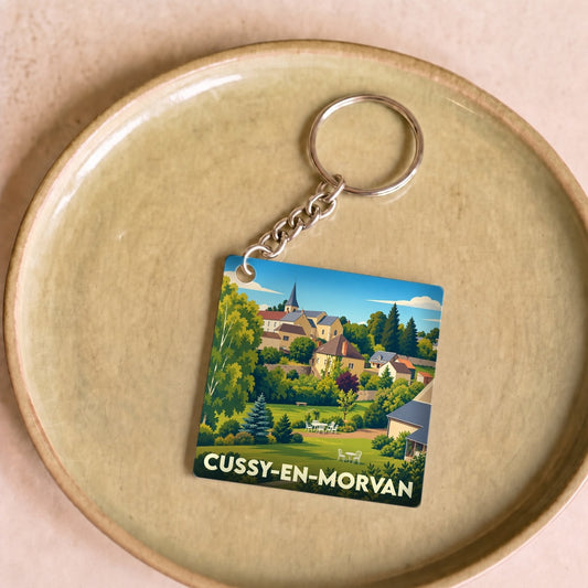 Porte-clés souvenir de la ville de Cussy-en-Morvan avec une illustration stylisée d'un paysage de village.