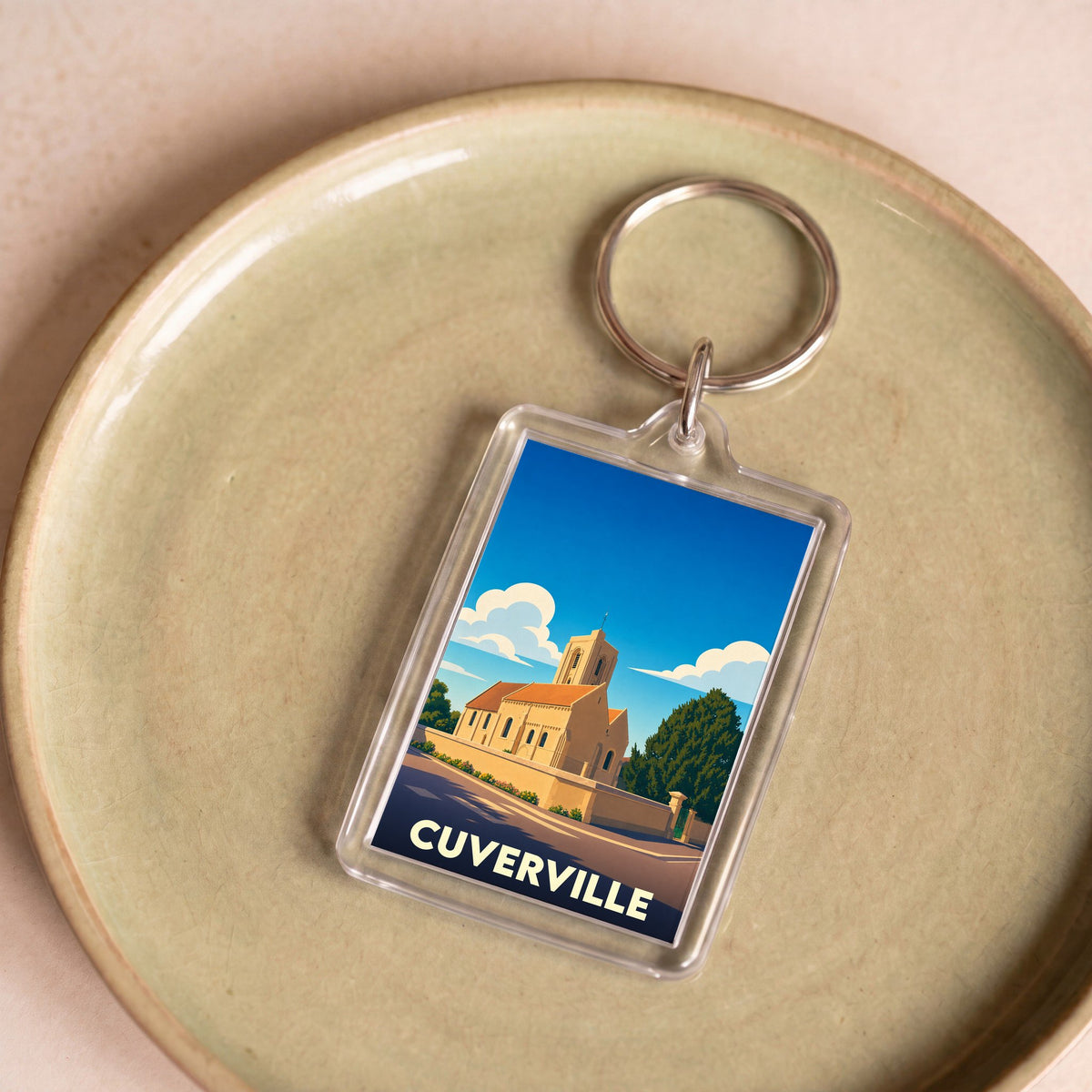 Porte-clés souvenir de la ville de Cuverville avec une illustration stylisée de son église.